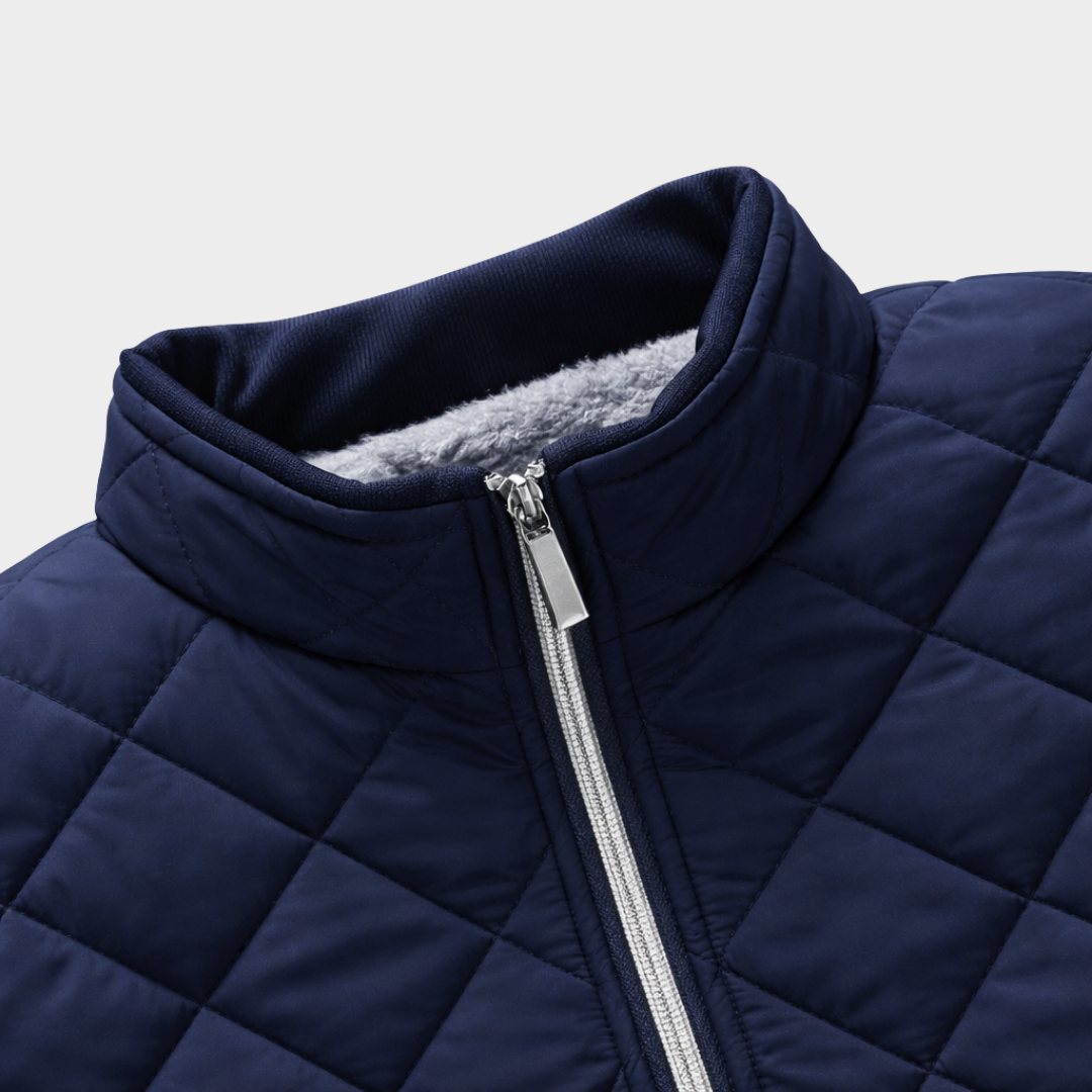 Close-up of the navy quilted jacket stand collar, zipper closure, and diamond-stitched fabric detailing.