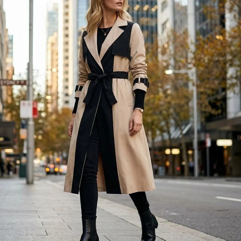 Colorblock Belted Longline Trench Coat worn by a female model, featuring contrasting panels, notch lapels, a waist belt, buckle cuff straps, and a longline silhouette.