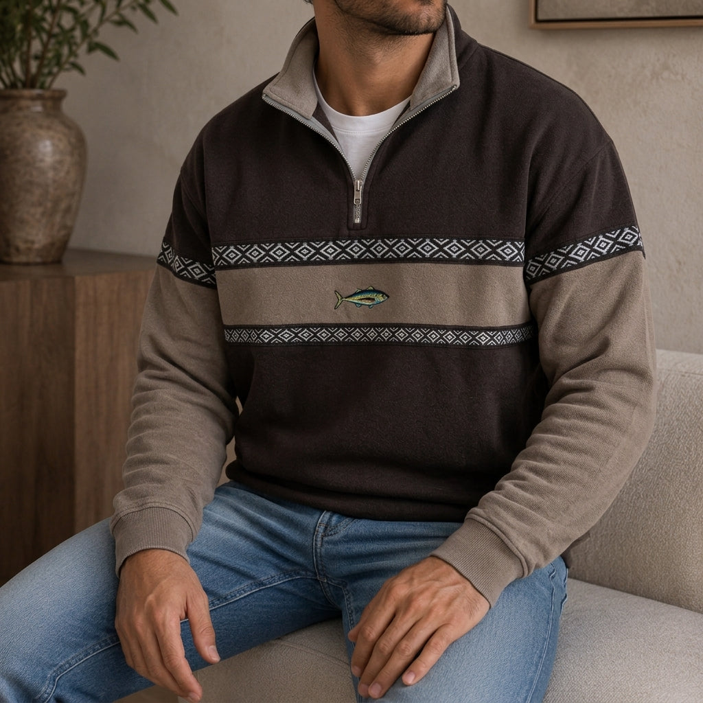 Dark brown and beige colorblock quarter-zip pullover worn by a male model, featuring a geometric chest band.