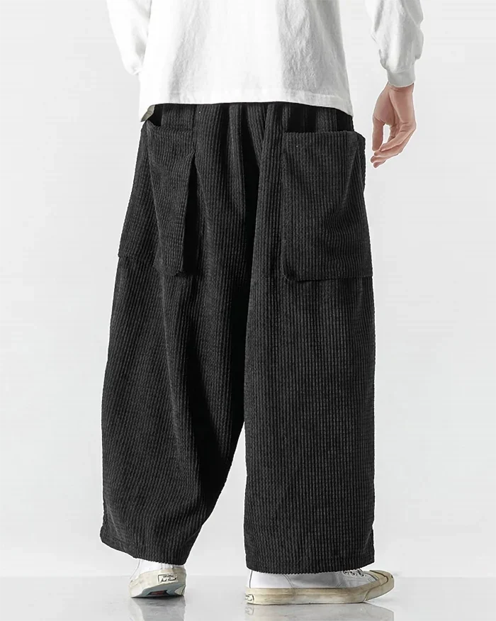 Black corduroy cargo pants shown from the back with relaxed wide-leg fit