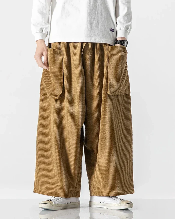 Tan corduroy cargo pants with oversized front pockets and relaxed wide-leg fit