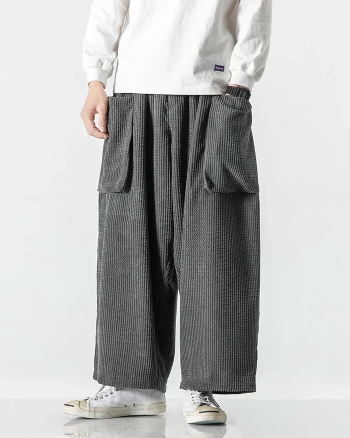 Gray corduroy cargo pants with wide legs and oversized utility pockets