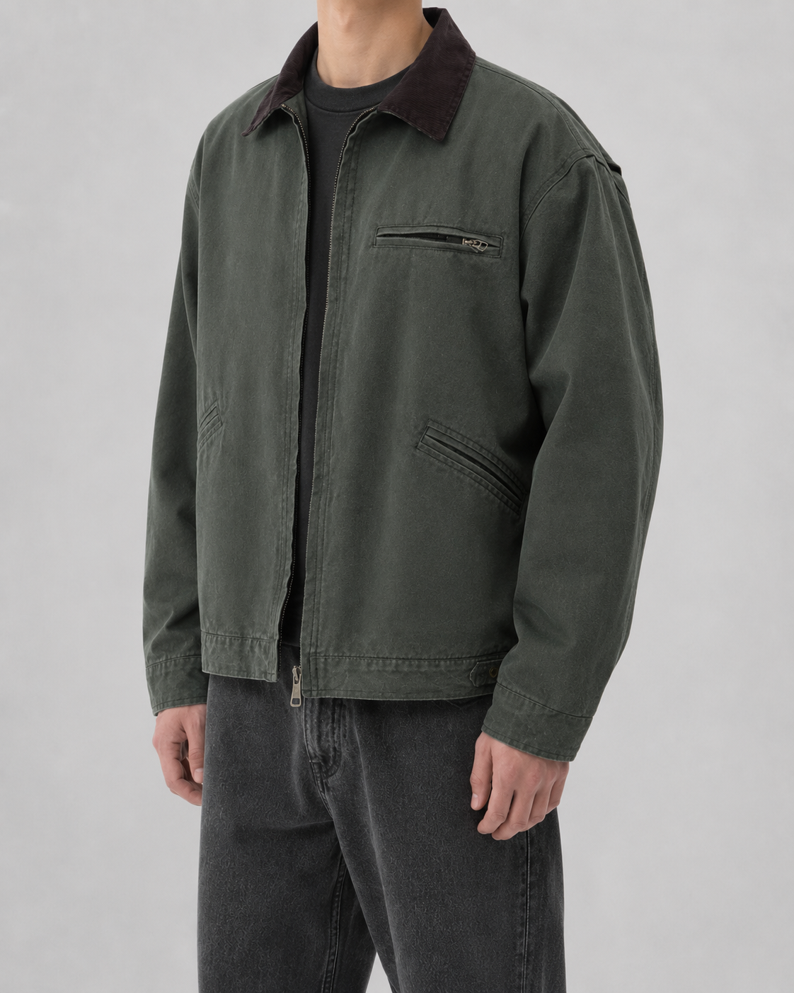 Three-quarter front view of a model wearing the dark washed-green cotton canvas jacket with brown corduroy collar.
