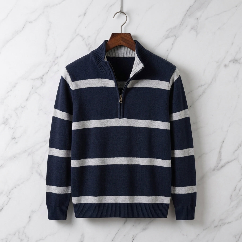 Navy blue cotton knit quarter-zip sweater with contrast horizontal stripes and ribbed mock neck shown on a hanger.