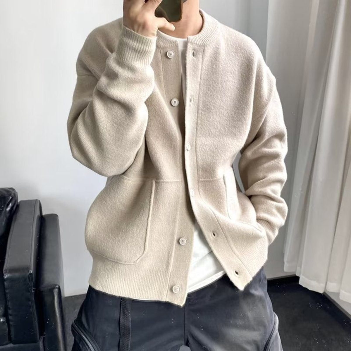 Beige brushed knit crew neck cardigan with a button-up front, dropped shoulders, and front patch pockets.