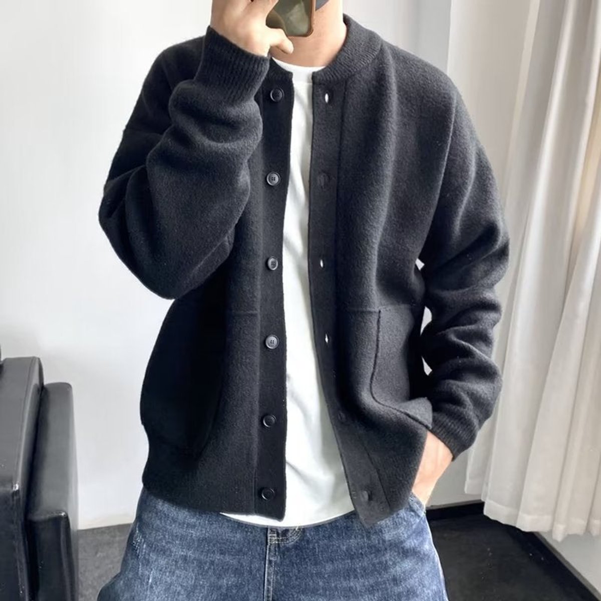 Black brushed knit crew neck cardigan with a button-up front, patch pockets, and a relaxed, dropped-shoulder fit.
