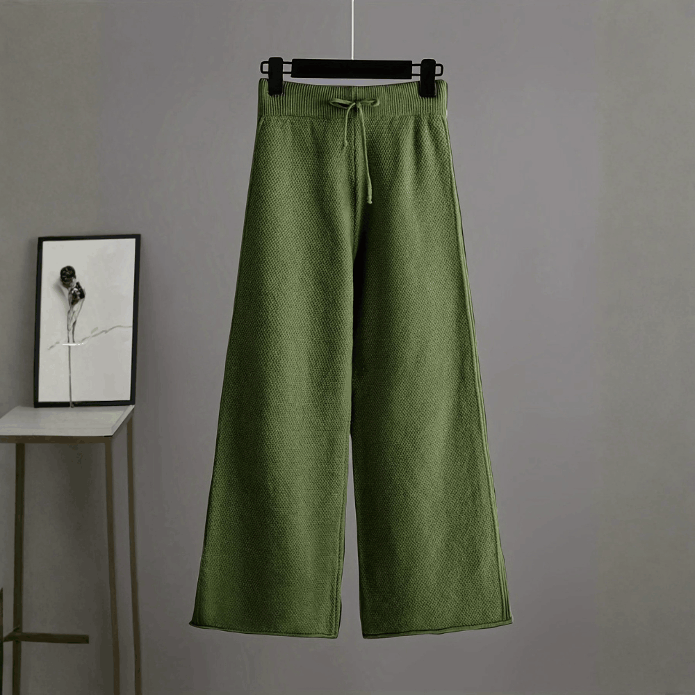 Front view of the high-waisted olive green wide-leg knit trousers on a hanger displaying the drawstring waist detail.