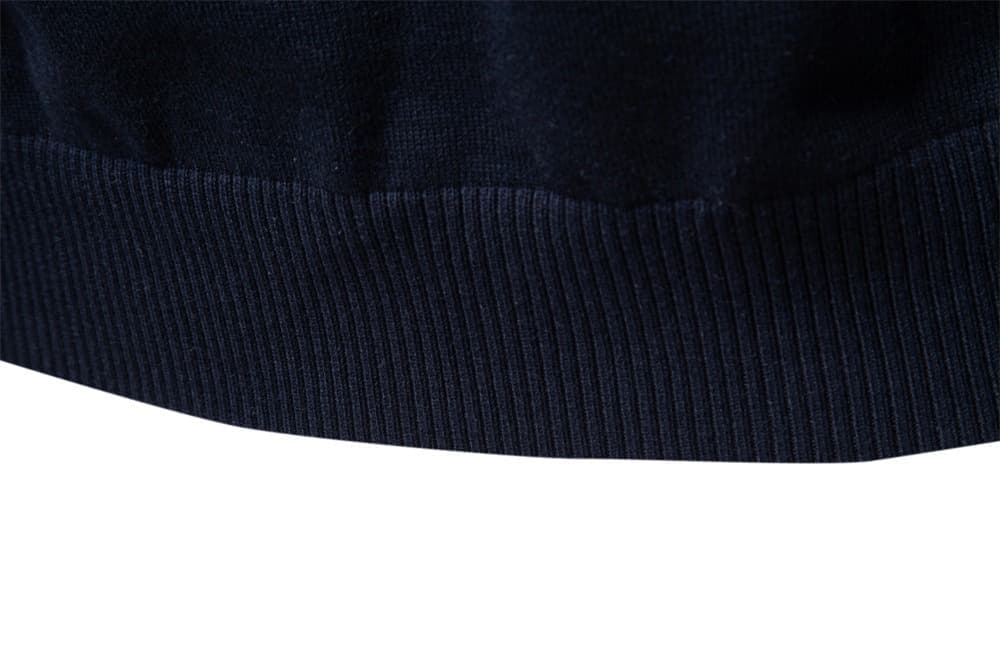 Close-up of the navy knit sweater ribbed hem highlighting the premium knit finish.