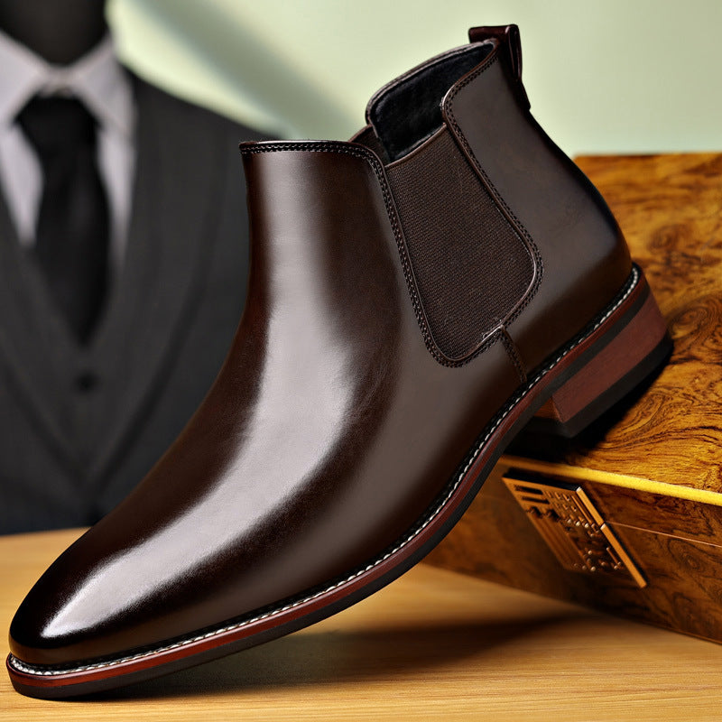 Burnished dark brown leather Chelsea boot with a pointed toe, elastic side panels, stitched welt, and stacked heel.