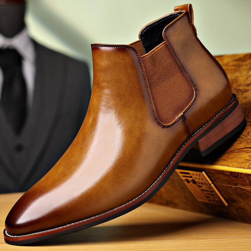 Burnished tan leather Chelsea boot with a pointed toe, elastic side panels, stitched welt, and a low stacked heel.