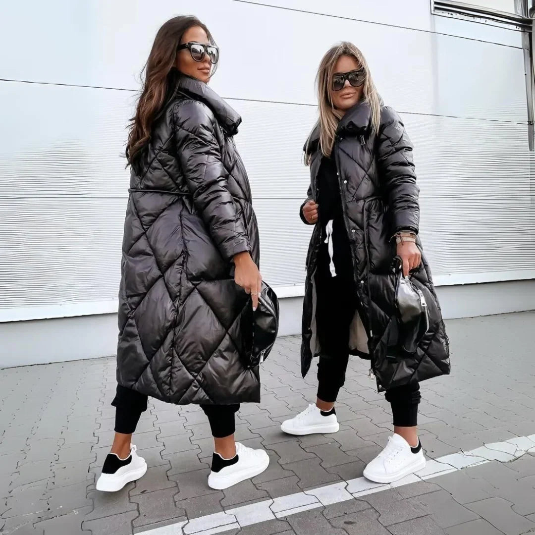 Black longline puffer coat with diamond quilting, high-shine finish, and oversized funnel collar worn over joggers.