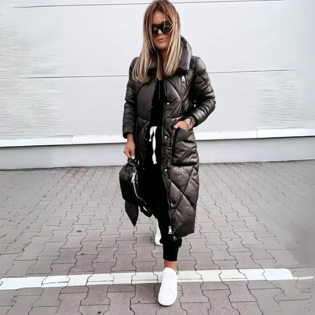 Black longline puffer coat with diamond quilting, high-shine finish, and oversized funnel collar worn over casual joggers.