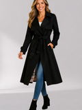Black Double-Breasted Belted Longline Trench Coat worn by a female model, featuring a storm flap, epaulets, strap cuffs, button front, and belted waist.