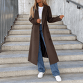 Dark brown longline coat with notched lapels and double-breasted buttons, worn over a white tee and blue jeans on stairs.