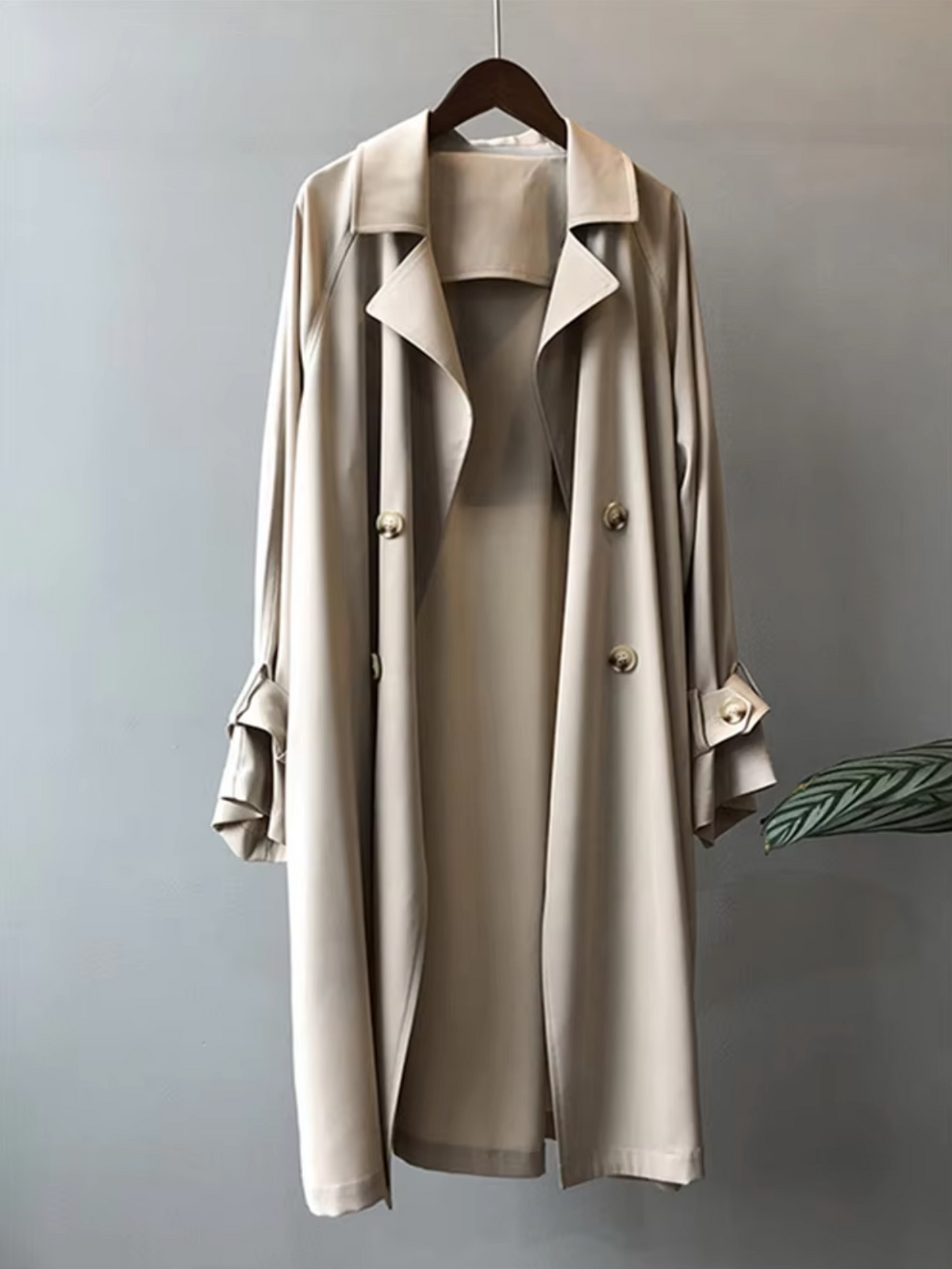 Beige Double-Breasted Longline Trench Coat displayed on a hanger, featuring notch lapels, button front, longline silhouette, and button-tab cuffs.