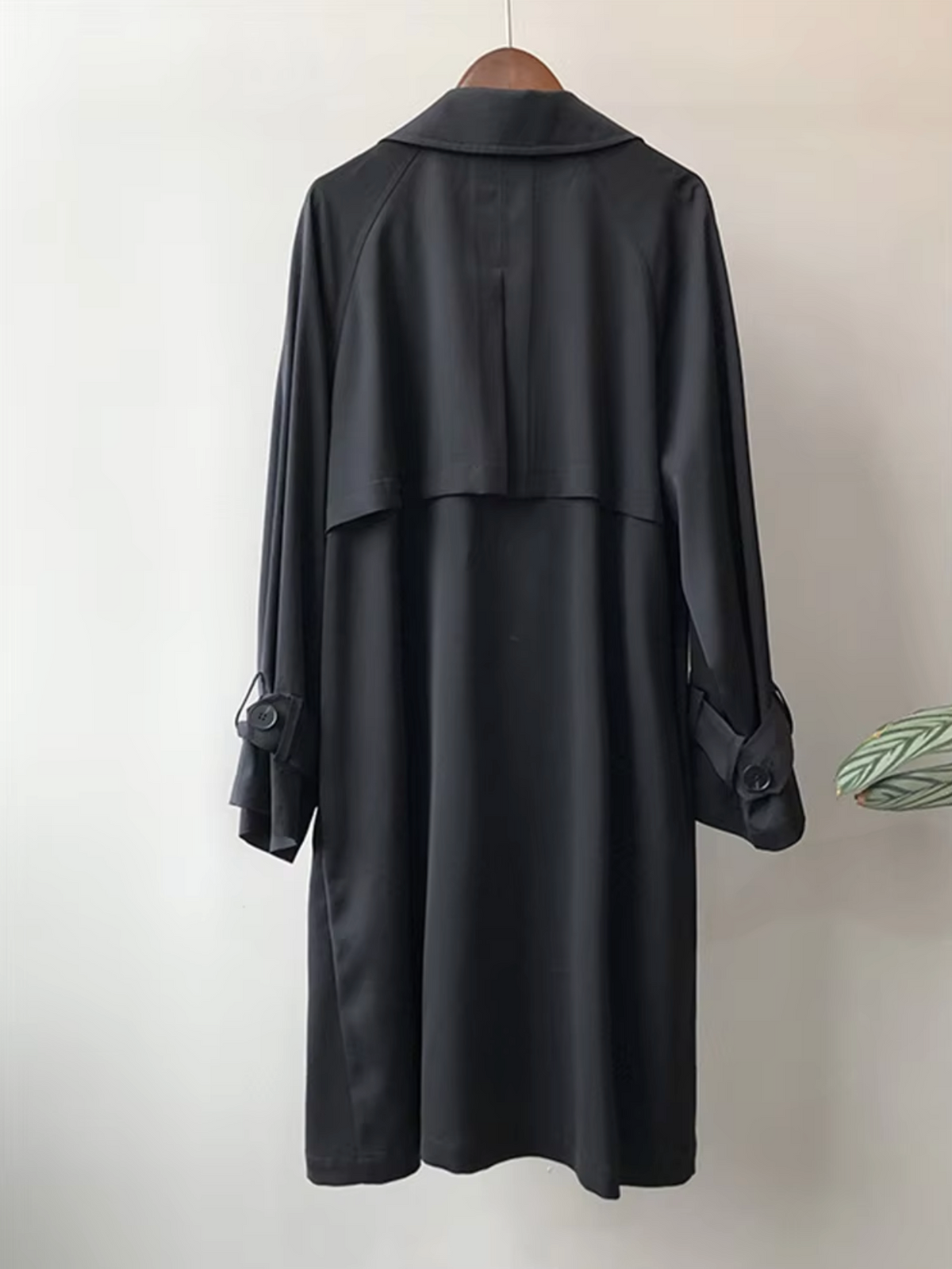 Back view of the black Double-Breasted Longline Trench Coat, highlighting the longline silhouette, back panel, and button-tab cuffs.