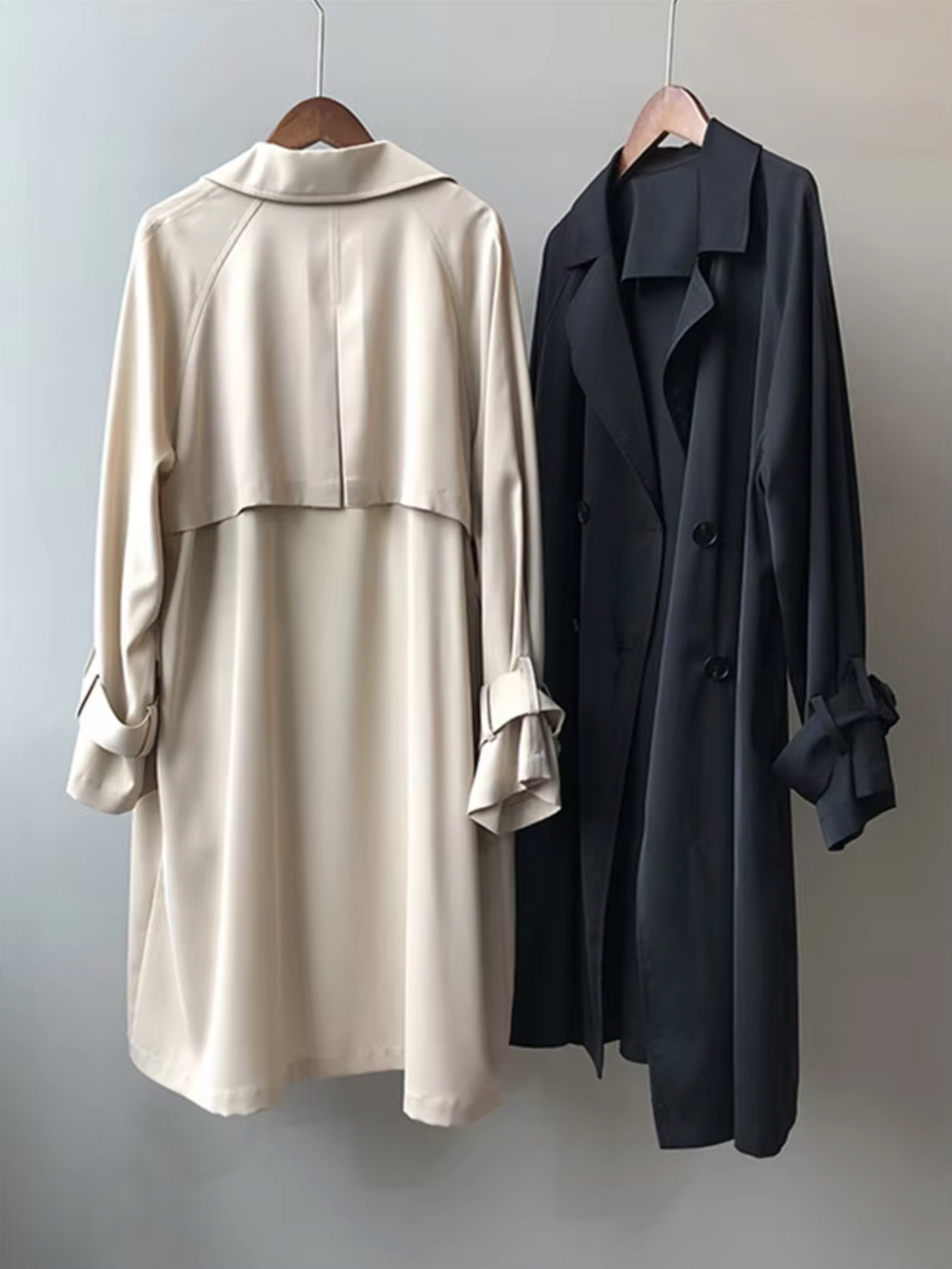 Beige and black Double-Breasted Longline Trench Coats displayed side by side, featuring notch lapels, button fronts, and longline silhouettes.