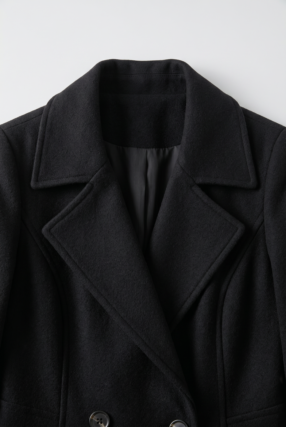 Close-up of the black Double-Breasted Midi Trench Coat showing the wide notch lapels, structured collar, and double-breasted front.