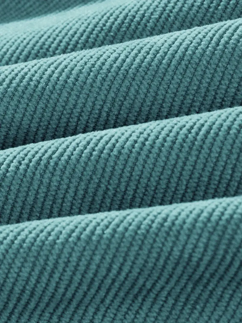 Close-up of fine-rib corduroy texture on teal pants