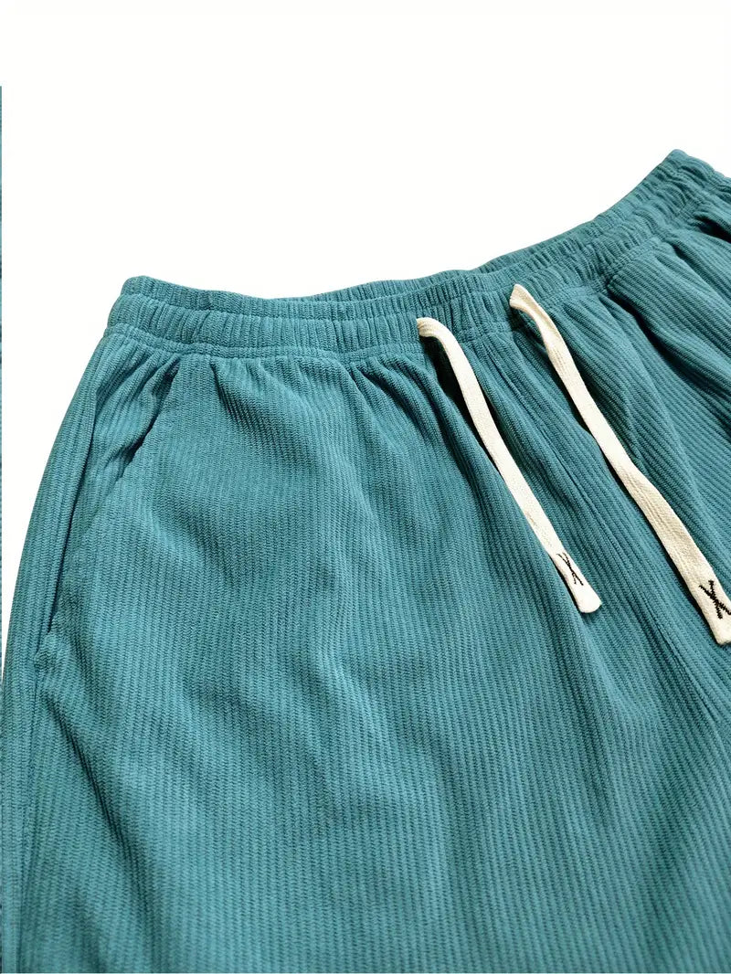 Close-up of teal corduroy pants showing the elastic waistband and drawstrings