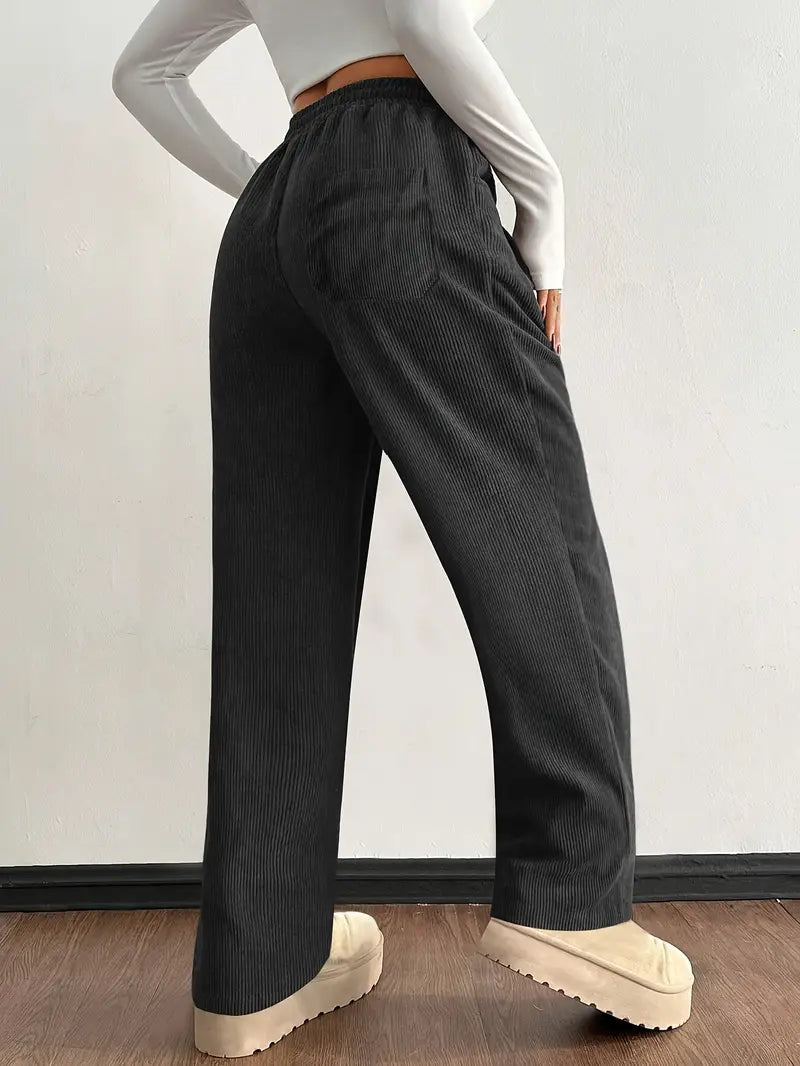 Black corduroy pants shown from the side with wide-leg fit