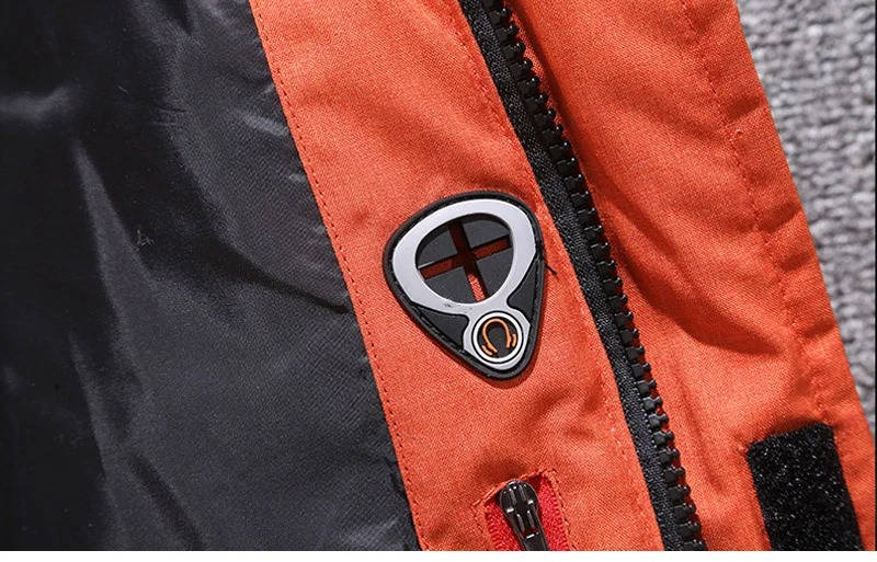 Close-up of an orange water-resistant nylon parka featuring a black zipper, internal polyester lining, and a branded tab.
