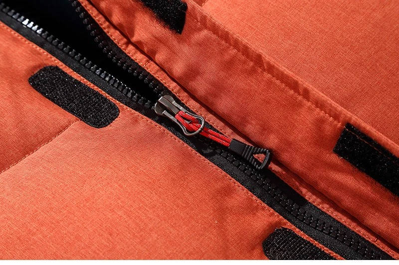 Rust-orange nylon parka featuring a durable black front zipper, reinforced storm flap, and secure velcro closures.