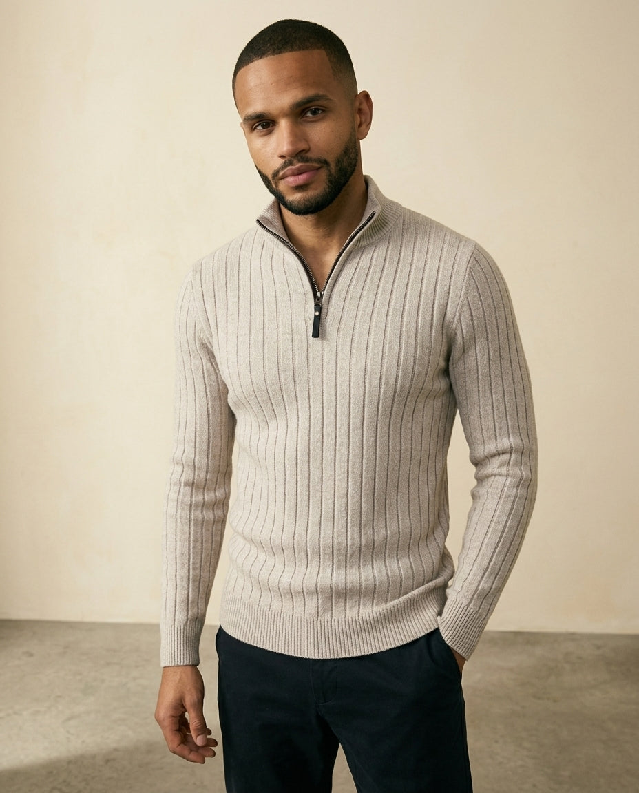 Beige ribbed quarter-zip sweater with a stand collar and regular fit, worn over dark trousers.
