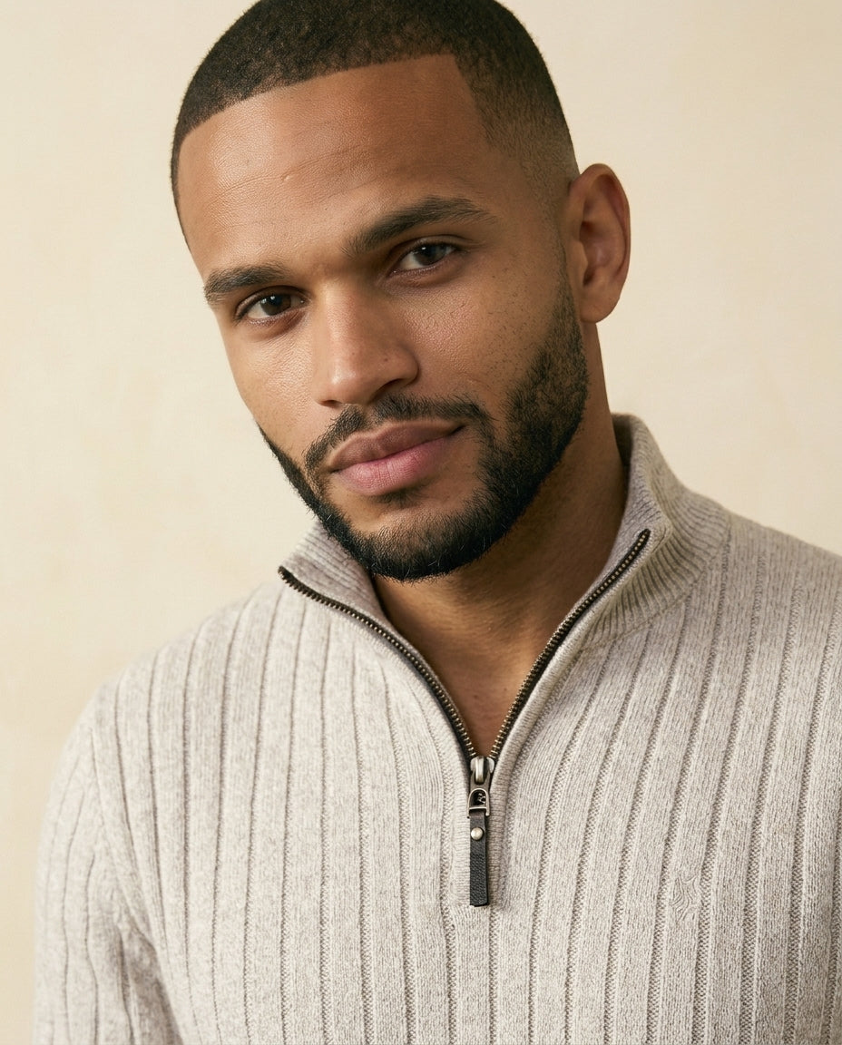 Beige ribbed quarter-zip sweater with a stand collar and textured vertical knit columns worn by a man.