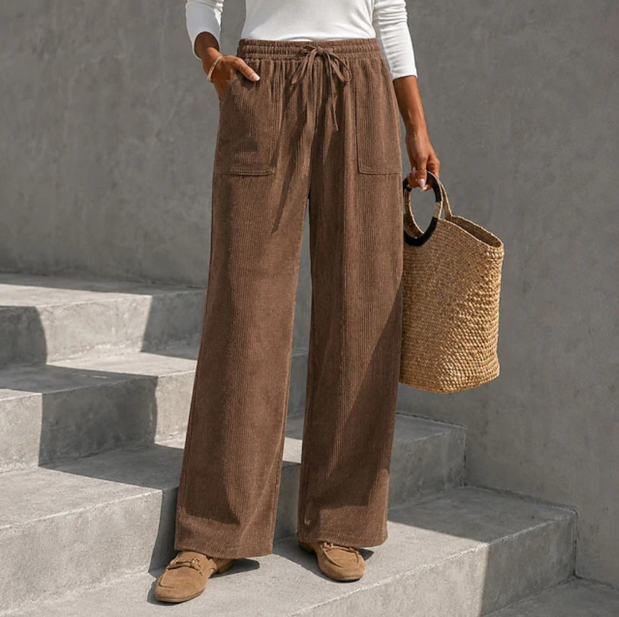 Brown wide-leg corduroy pants featuring an elastic drawstring waist, front patch pockets, and a relaxed, full-length fit.