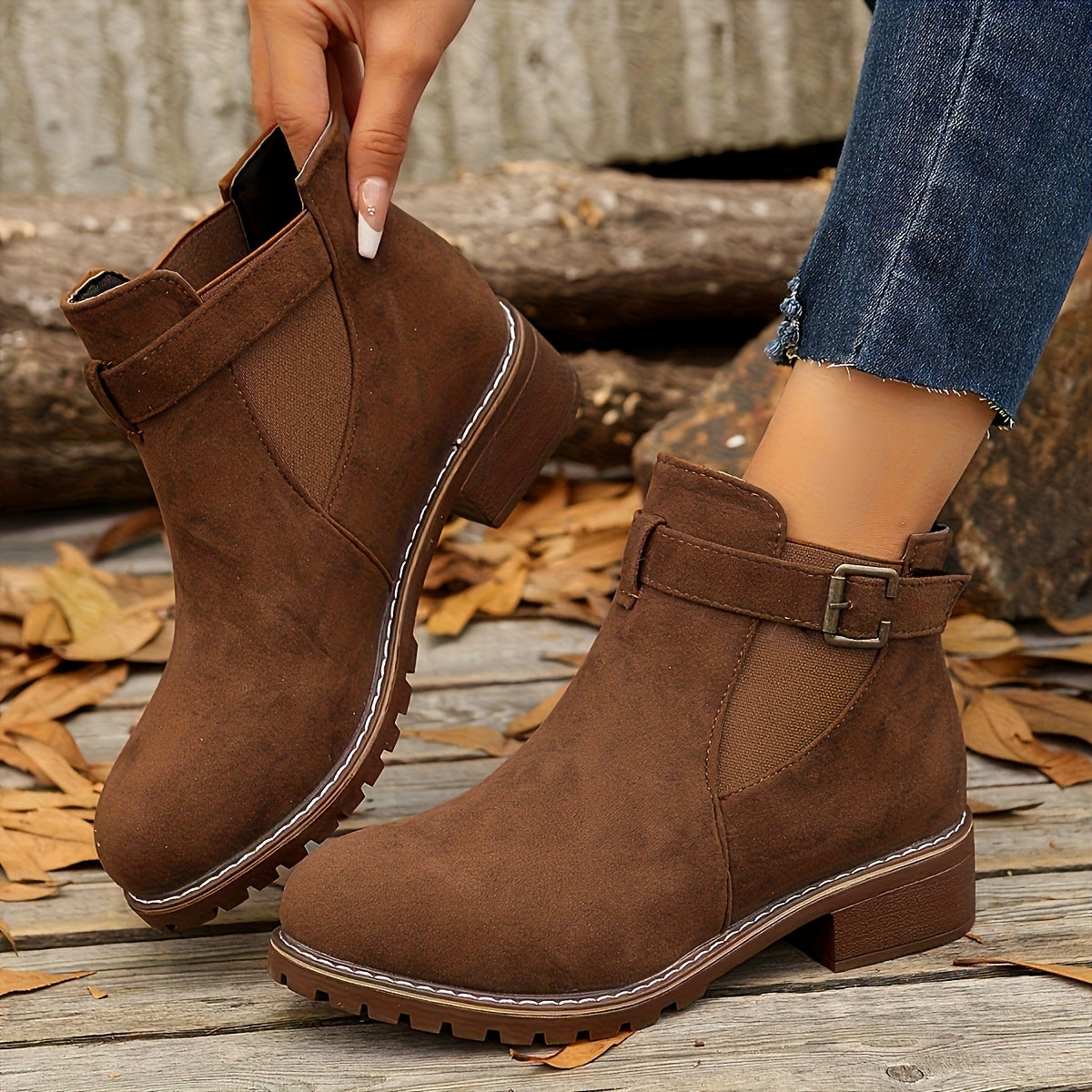 Brown suede Chelsea ankle boots with buckle straps, elastic side panels, and a rugged lug sole block heel.