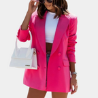 Hot pink double-breasted blazer with structured shoulders and a tailored, mid-length fit worn over a white crop top.