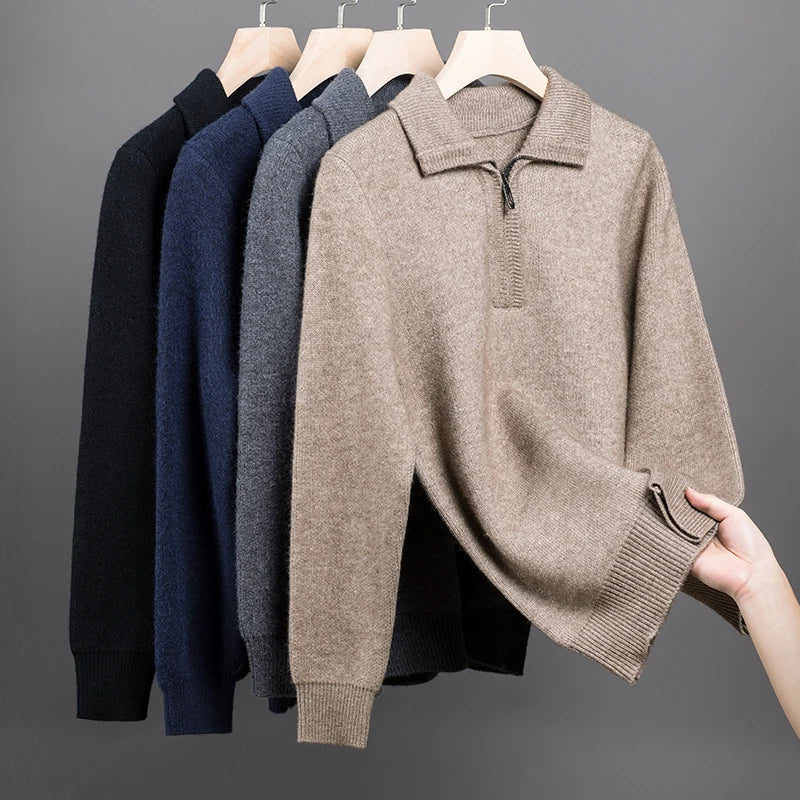 Mid-weight knit quarter zip polo sweaters in neutral tones with folded collars and ribbed cuffs hanging on wooden hangers.