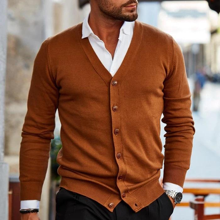 Tobacco brown fine-gauge V-neck cardigan with a button front, layered over a crisp white collared shirt and black trousers.