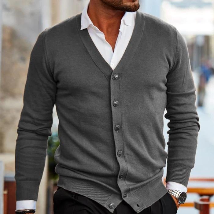 Charcoal gray fine-gauge V-neck cardigan with a button-front closure, ribbed cuffs, and hem layered over a crisp white shirt.