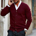 Burgundy fine-gauge V-neck cardigan with a button front, worn over a white collared shirt and dark trousers.