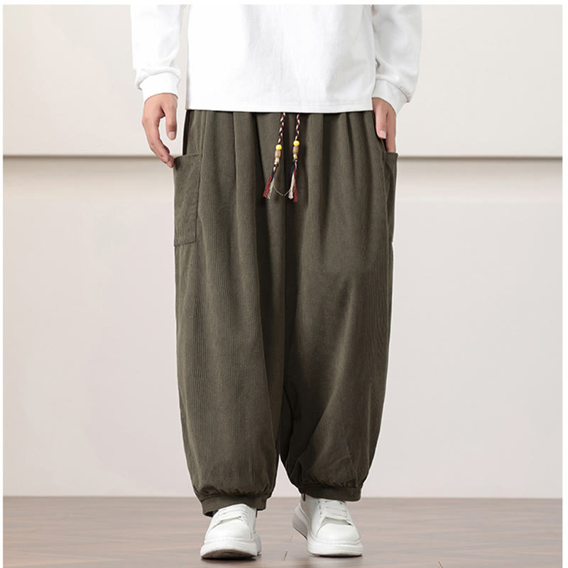 Olive green fine-wale corduroy harem pants with side patch pockets, a beaded drawstring waist, and cuffed ankles.