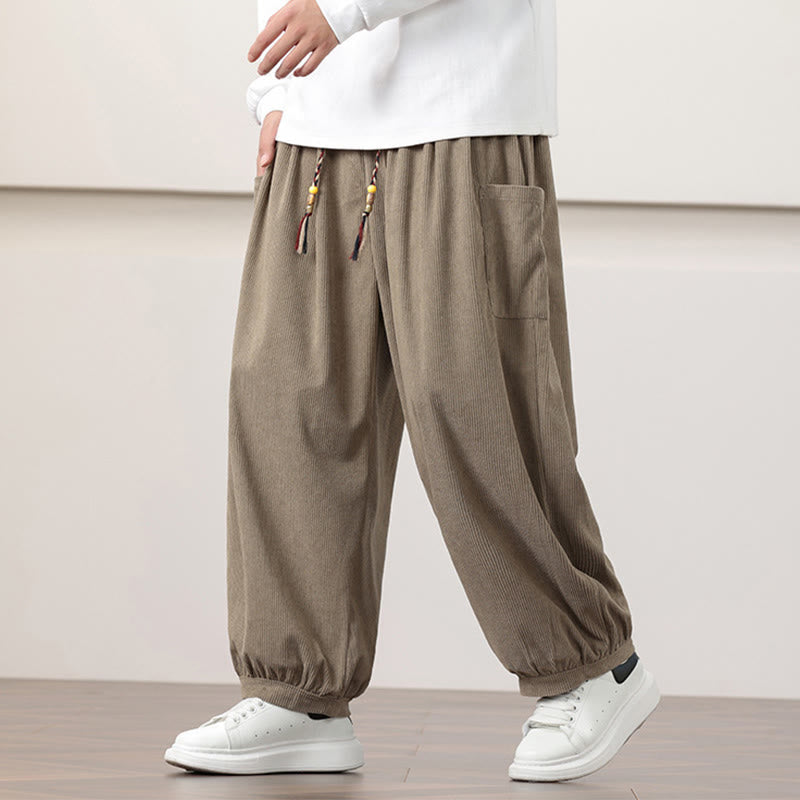 Dark khaki fine-wale corduroy harem pants with a beaded drawstring waist, side patch pockets, and gathered cuffed ankles.