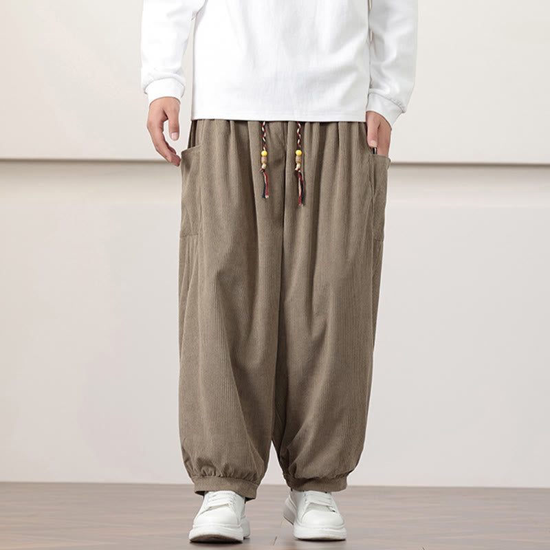 Dark khaki fine-wale corduroy harem pants with side patch pockets, beaded drawstring waist, and cuffed ankles.
