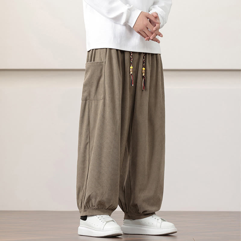 Dark khaki fine-wale corduroy harem pants with side patch pockets, beaded drawstring waist, and gathered cuffed ankles.