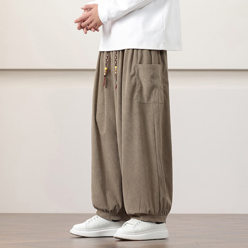Dark khaki  fine-wale corduroy harem pants with side patch pockets, beaded drawstring waist, and cuffed ankles worn with sneakers.