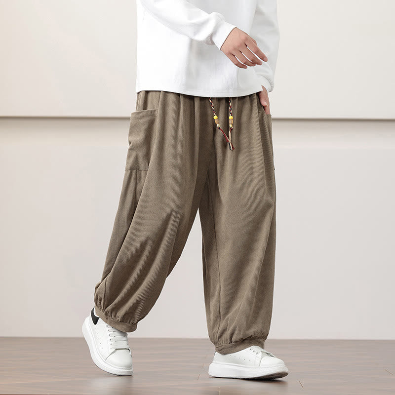 Dark khaki fine-wale corduroy harem pants with side patch pockets, beaded drawstring waist, and cuffed ankles.