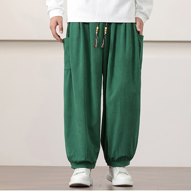 Green fine-wale corduroy harem pants with side patch pockets, a beaded drawstring waist, and cuffed ankles.