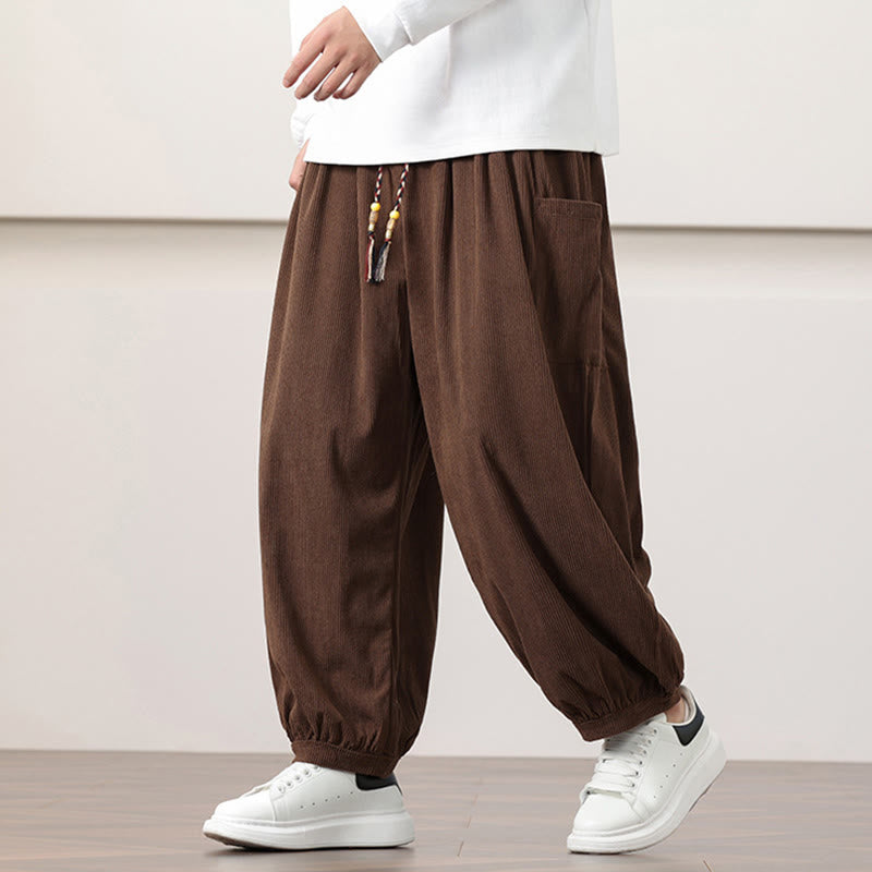 Brown fine-wale corduroy harem pants with a beaded drawstring waist, side patch pockets, and cuffed ankles.