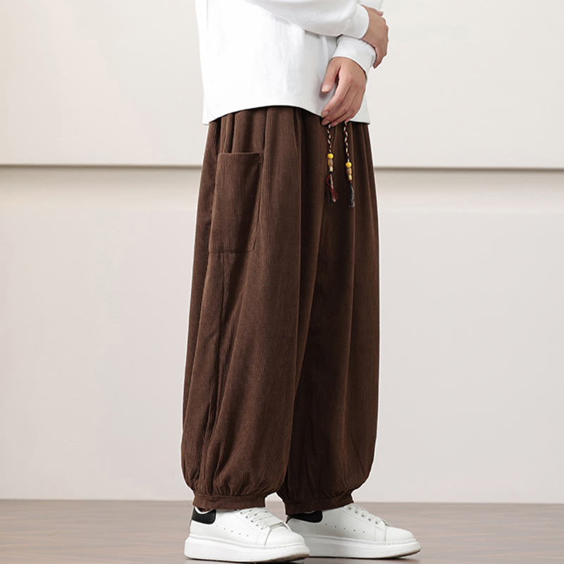 Brown fine-wale corduroy harem pants with side patch pockets, a beaded drawstring waist, and cuffed ankles.