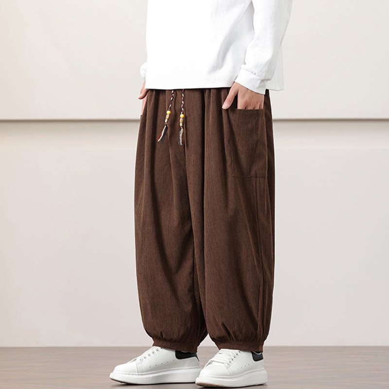 Brown fine-wale corduroy harem pants featuring side patch pockets, a beaded drawstring waist, and cuffed ankles.