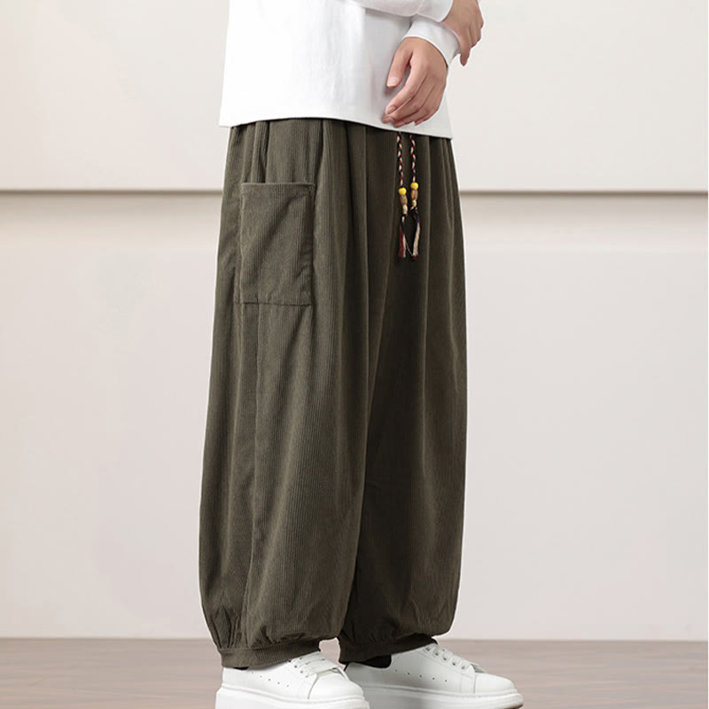 Olive green fine-wale corduroy harem pants featuring side patch pockets, a beaded drawstring waist, and cuffed ankles.
