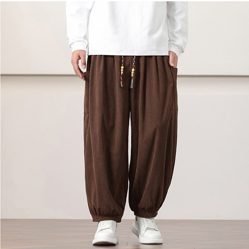 Brown fine-wale corduroy harem pants featuring side patch pockets, a beaded drawstring waist, and gathered cuffed ankles.