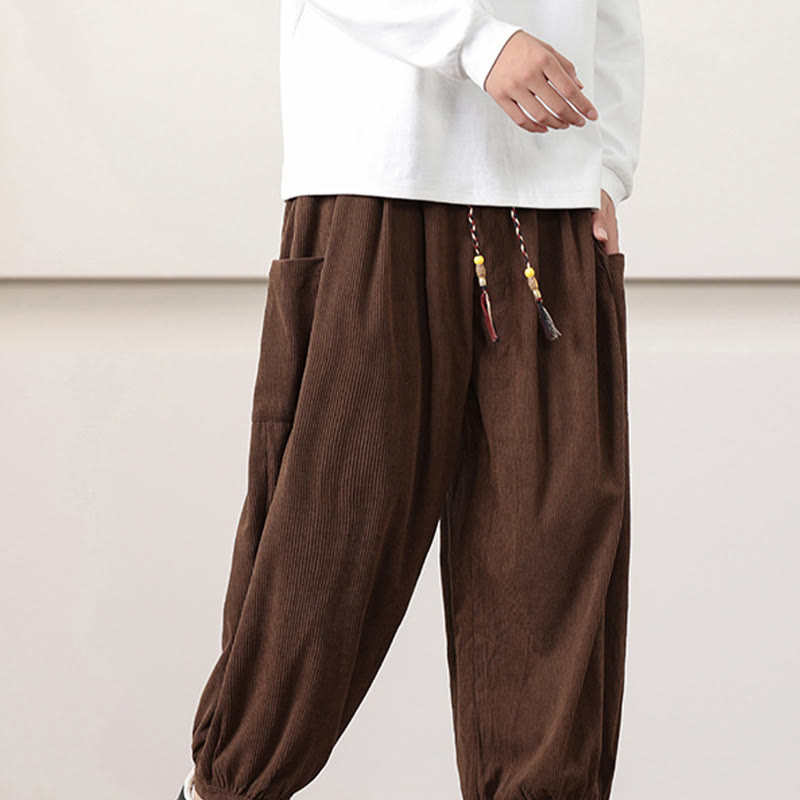 Brown fine-wale corduroy harem pants with side patch pockets, beaded drawstring waist, and cuffed ankles.