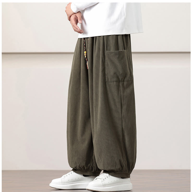 Olive green fine-wale corduroy harem pants with side patch pockets, beaded drawstring waist, and cuffed ankles.